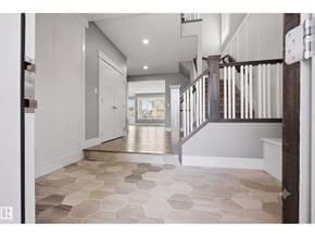 Edmonton apartment for rent - A hallway with a tiled floor and a staircase on the right side.