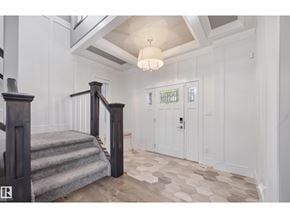 Edmonton apartment for rent - A staircase with a wooden handrail and a light grey carpeted runner leads to a landing with a white door and a window.
