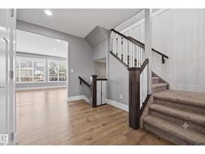 Edmonton apartment for rent - A staircase with a beige carpeted runner and wooden steps leads to a second floor.