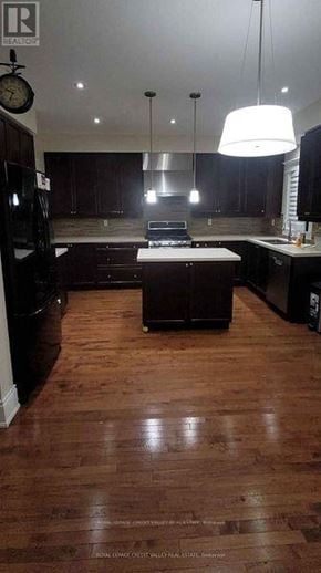 Brampton (Fletcher's Meadow) apartment for rent - A kitchen with dark wood floors and a large island in the middle.