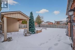 Hamilton (Stoney Creek) apartment for rent - A snow-covered yard with a wooden fence and a small tree.