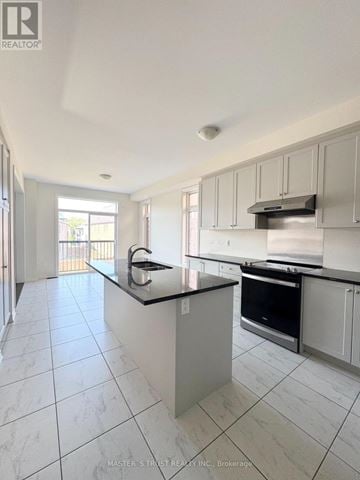 East Gwillimbury (Holland Landing) apartment for rent - A kitchen with white cabinets and a black countertop.