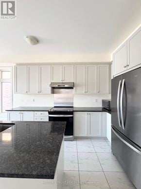 East Gwillimbury (Holland Landing) apartment for rent - A kitchen with a black counter top and stainless steel appliances.