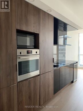 Toronto (Bay Street Corridor) condo for rent - A modern kitchen with a wooden cabinet and stainless steel appliances.