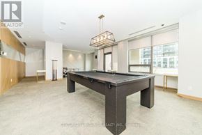 Markham (Unionville) condo for rent - A spacious room with a black table in the center and a chandelier hanging from the ceiling.