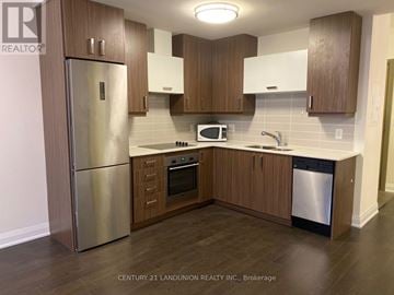Markham (Unionville) condo for rent - A kitchen with wooden cabinets and a stainless steel refrigerator.