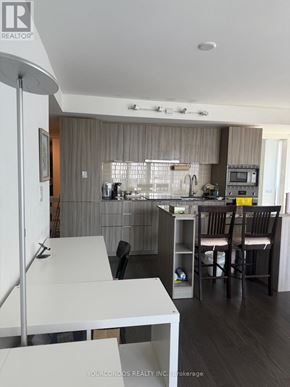 Toronto (Bay Street Corridor) condo for rent - A modern kitchen with a dining table and chairs.