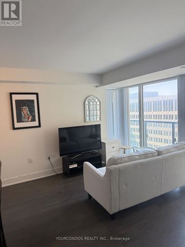 Toronto (Bay Street Corridor) condo for rent - A living room with a grey couch and a television.