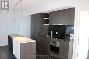 Toronto (Waterfront Communities) condo for rent - A modern kitchen with dark wood cabinets and a white island.