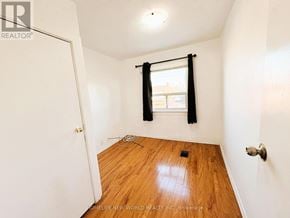 Toronto (Corso Italia-Davenport) apartment for rent - A room with a wooden floor and a window with black curtains.