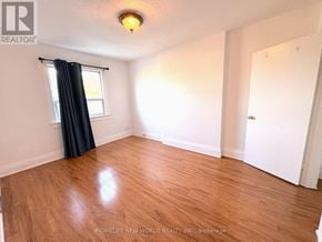 Toronto (Corso Italia-Davenport) apartment for rent - A room with wooden flooring and a window with black curtains.