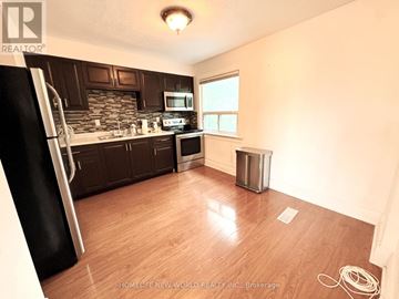 Toronto (Corso Italia-Davenport) apartment for rent - A kitchen with wooden floors and a black refrigerator.