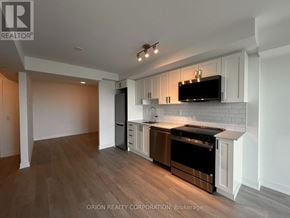 Pickering (Bay Ridges) condo for rent - A kitchen with white cabinets and a black stove top oven.