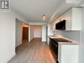 Pickering (Bay Ridges) condo for rent - A kitchen with a black stove top oven and white cabinets.