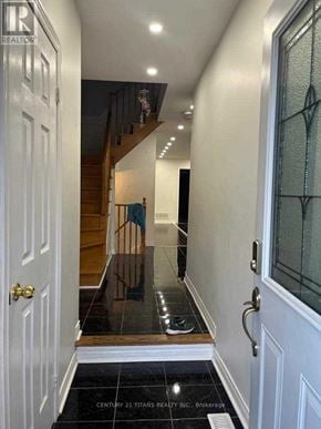 Ajax (Northwest Ajax) townhouse for rent - A hallway with a glass door and a wooden staircase.