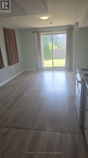 Ajax (Northwest Ajax) townhouse for rent - A kitchen with wooden flooring and a sliding glass door leading to a backyard.