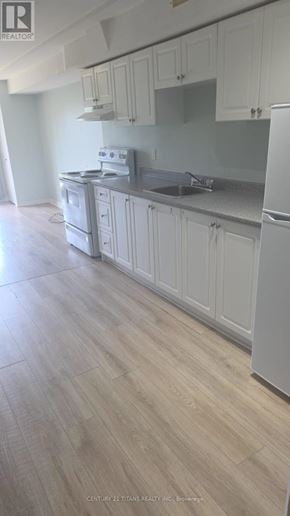 Ajax (Northwest Ajax) townhouse for rent - A kitchen with white cabinets and a wooden floor.