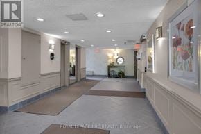 St. Catharines (Fairview) condo for rent - A hallway with a Royal LePage NRC Realty sign on the wall.