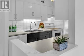 St. Catharines (Fairview) condo for rent - A white kitchen with a sink and a plant.