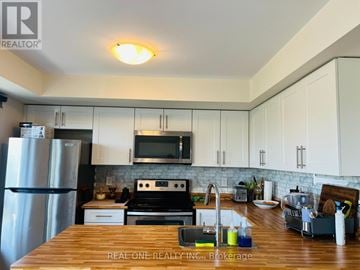 Markham (Cornell) townhouse for rent - A kitchen with a wooden counter top and white cabinets.