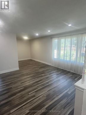 Brampton (Brampton South) apartment for rent - A room with wooden flooring and white walls.