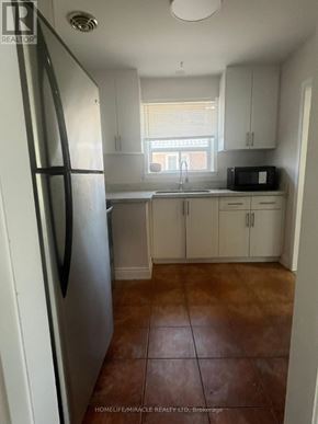 Brampton (Brampton South) apartment for rent - A kitchen with brown tiled floors and white appliances.
