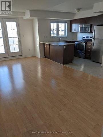 Oakville (Ro River Oaks) condo for rent - A kitchen with wooden floors and stainless steel appliances.