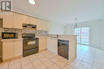 Brampton (Sandringham-Wellington) townhouse for rent - A kitchen with white cabinets and a stone backsplash.