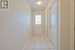 Brampton (Sandringham-Wellington) townhouse for rent - A hallway with white walls and a tiled floor.
