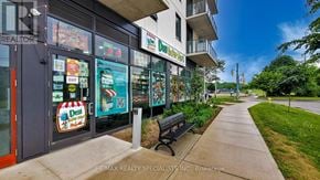 Brantford condo for rent - A sidewalk leads to a building with a sign that says "RE/MAX REALTY SPECIALISTS INC. Brokerage."