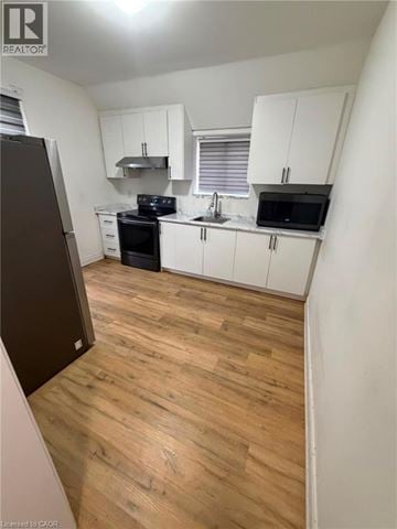 Brantford apartment for rent - A kitchen with white cabinets and a wooden floor.