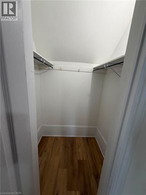 Brantford apartment for rent - A white hallway with wood flooring and a white ceiling.