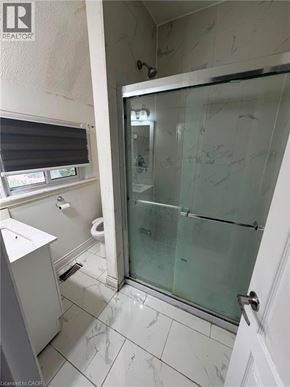 Brantford apartment for rent - A bathroom with a walk in shower and a toilet.