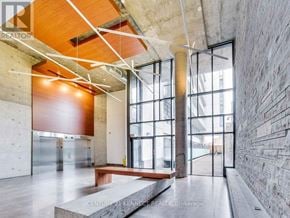 Toronto (Waterfront Communities) condo for rent - A modern interior space with a wooden ceiling and a stone wall.