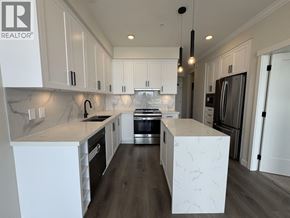 Maple Ridge apartment for rent - A modern kitchen with white cabinets and a central island.