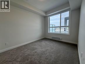 Maple Ridge apartment for rent - A room with a large window and a carpeted floor.