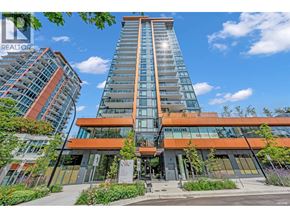 North Vancouver apartment for rent - A modern building with a glass facade and a sign that says "For Sale".