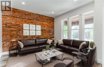 Hamilton (Gibson) apartment for rent - A living room with a brown leather couch and a brick wall.