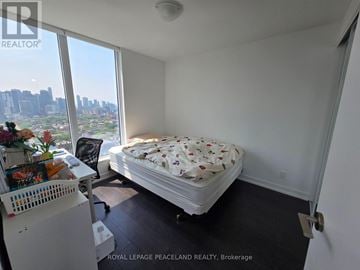 Toronto (University) condo for rent - A bedroom with a large bed and a view of the city.