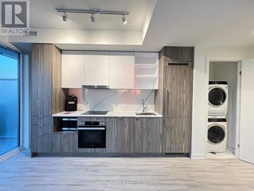 Toronto (Waterfront Communities) condo for rent - A modern kitchen with wooden cabinets and appliances.