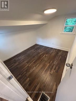 London South (South F) fourplex for rent - A room with wooden flooring and a window.