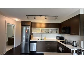 Surrey apartment for rent - A modern kitchen with dark brown cabinets and stainless steel appliances.