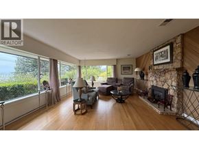 West Vancouver apartment for rent - A living room with a stone fireplace and a large window.