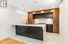 Ottawa apartment for rent - A modern kitchen with a black countertop and wooden cabinets.