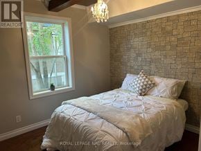 Port Colborne (Killaly East) apartment for rent - A bedroom with a bed, pillows, and a chandelier.