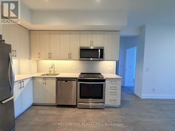 Toronto (Bayview Village) condo for rent - A kitchen with white cabinets and a stainless steel refrigerator.