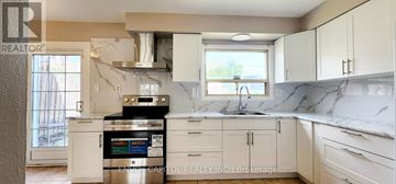 Toronto (Humbermede) apartment for rent - A kitchen with white cabinets and a marble countertop.