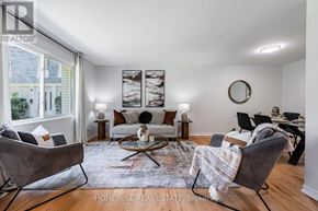 Mississauga (Applewood) townhouse for rent - A living room with a grey couch, a coffee table, and a large window.
