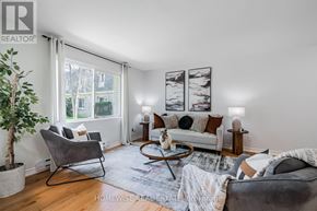 Mississauga (Applewood) townhouse for rent - A living room with a grey chair, a white couch, and a potted plant.