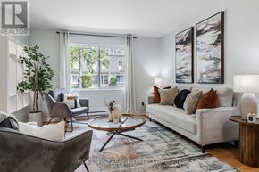 Mississauga (Applewood) townhouse for rent - A living room with a white couch, a coffee table, and a large window.